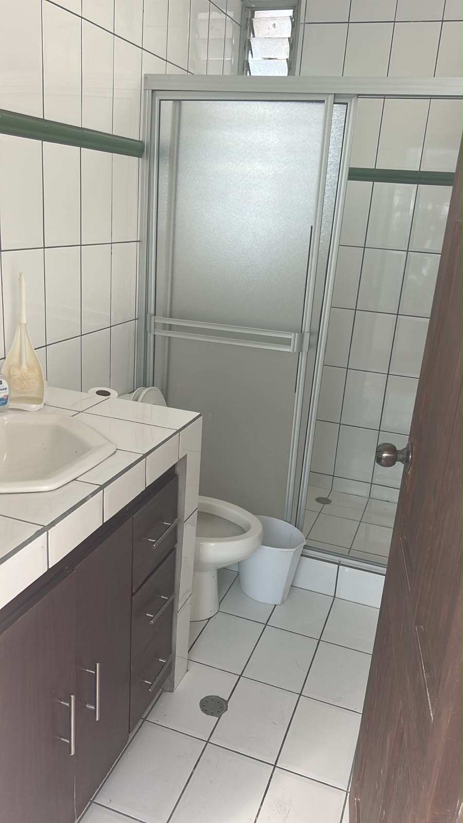 Baño con ducha y mueble de madera