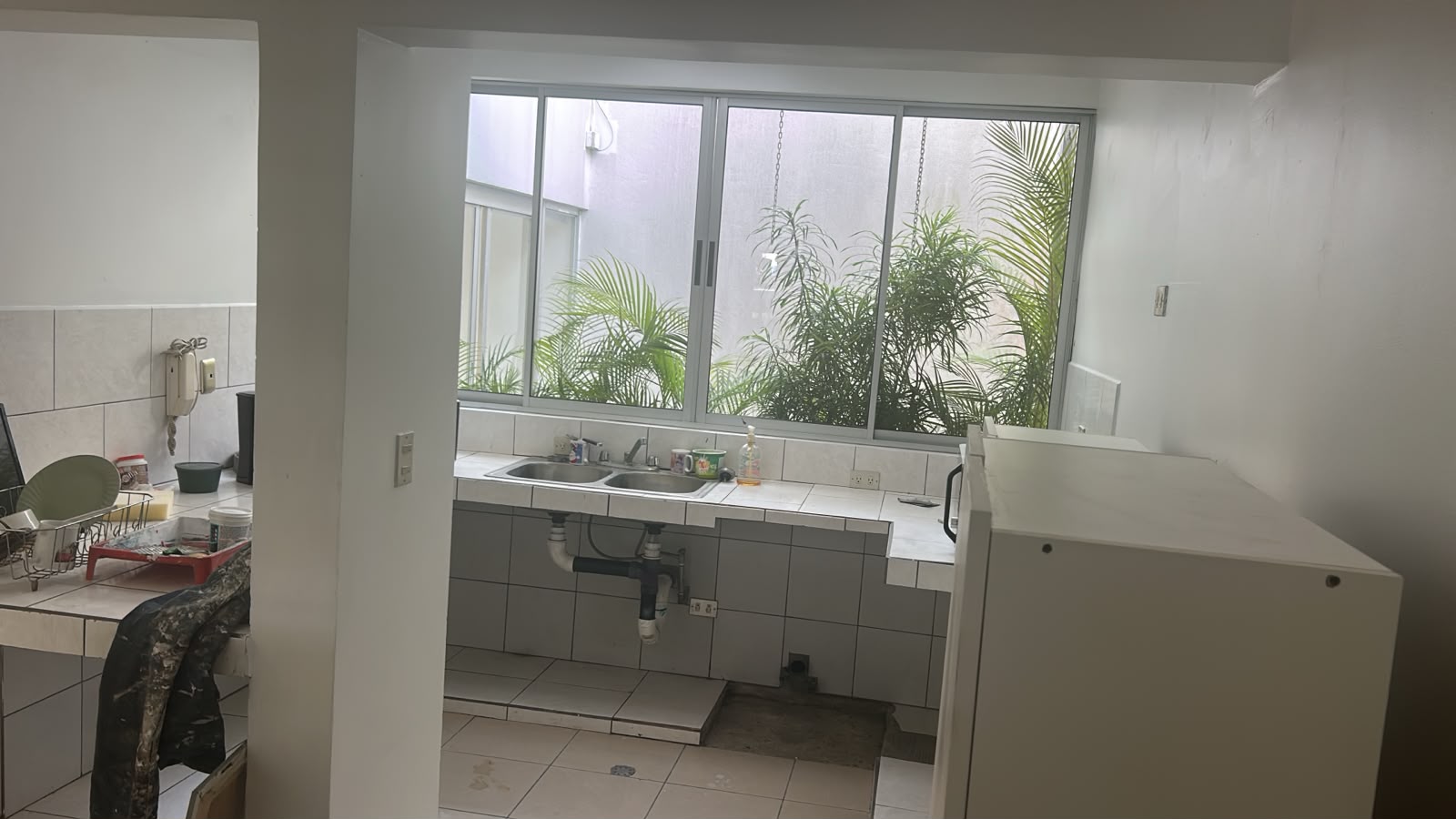Cocina con ventana hacia un pequeño jardín interior