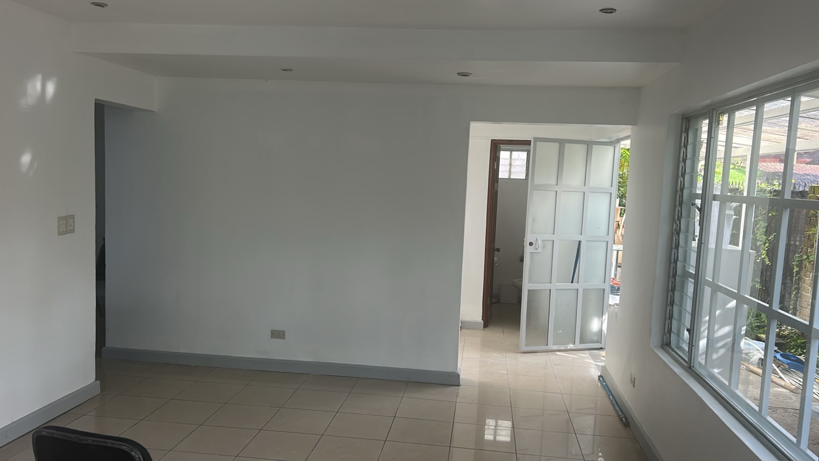 Sala amplia con puerta de vidrio y ventanas